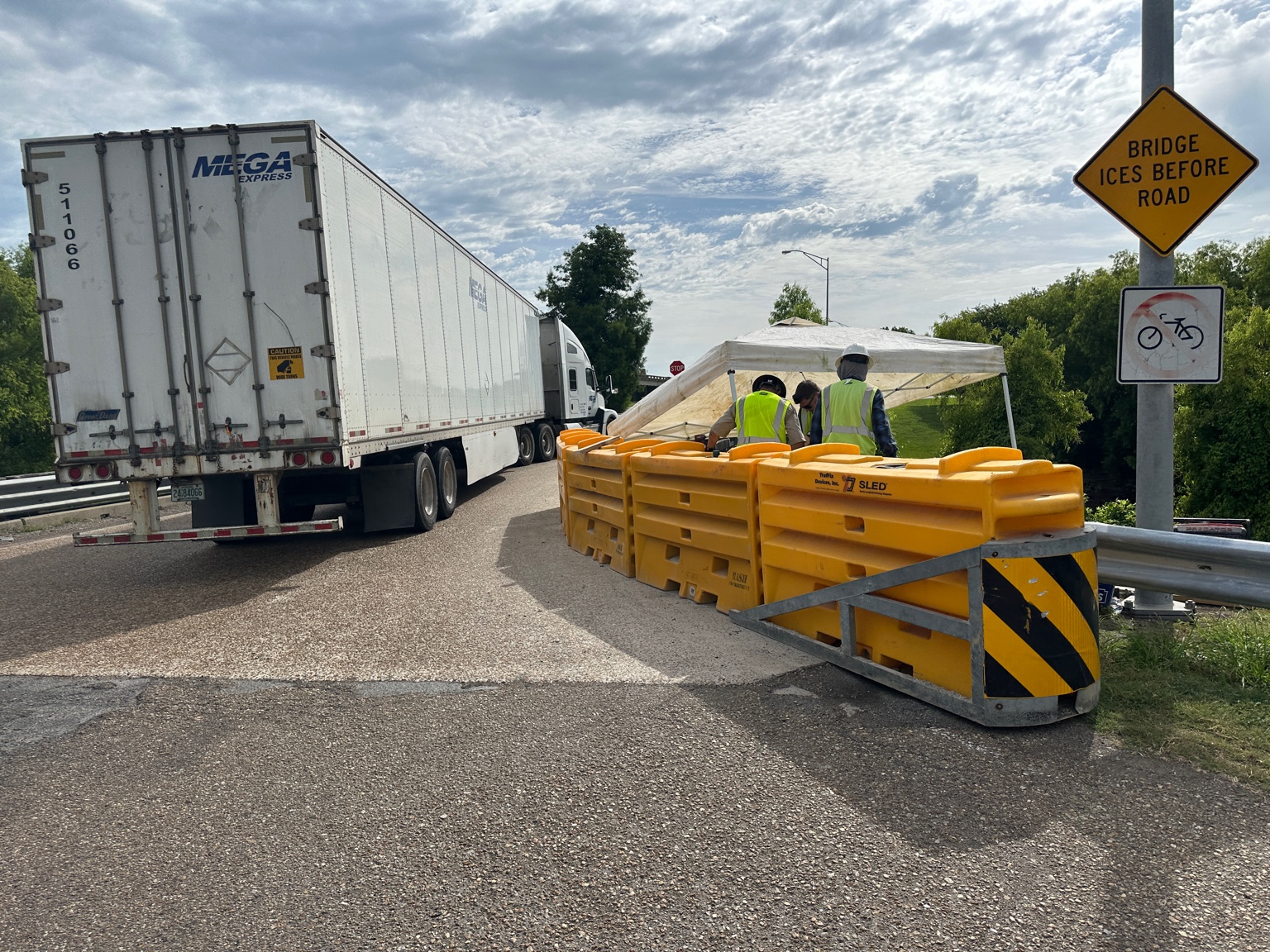 Highway crew working behind traffic barriers